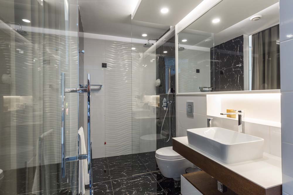 Bathroom remodeling in progress with tile installation and modern fixtures by ParrotWerks Construction in San Diego